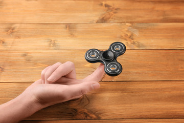 Woman rolling modern spinner on wooden background