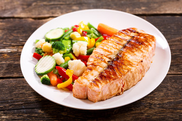 plate of grilled salmon steak with vegetables