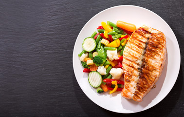 plate of grilled salmon steak with vegetables