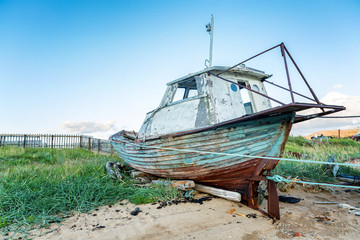an old wooden ship stands on a sandy beach