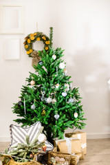 Beautifully decorated Christmas tree with presents under it in the room specially decorated for this holiday. Concept of Christmas, winter and New Year