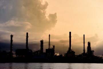 Silhouette of Oil Refinery Industry Plant in Bangkok, Thailand with cloudy vivid sunrise background. Conventional energy concept.