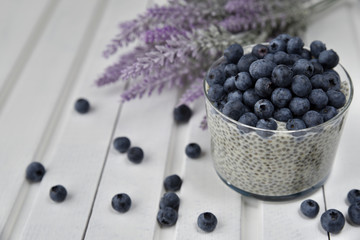 Полезный завтрак: пудинг чиа с черникой на салфетке, белый деревянный фон