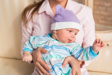 Close up portrait of cute baby boy wearing purple hat.