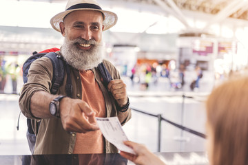 Outgoing grandfather getting ticket in booking office