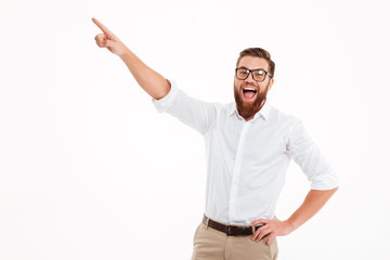 Happy excited bearded man in eyeglasses pointing