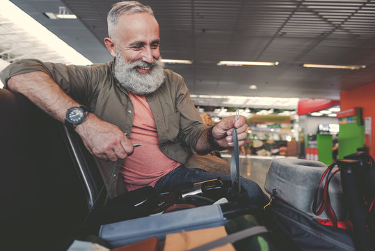 Outgoing pensioner watching at bag in airport
