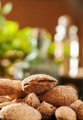 Macro shot of almond in shell with kitchen stuff in the background, vertical