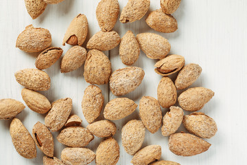 Almond in shell on a white table, top view