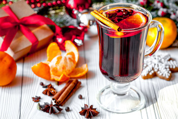 Christmas mulled wine with spices in cup on wooden background