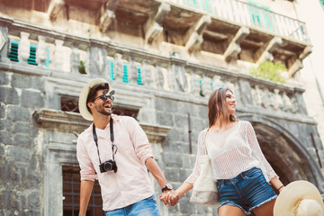 Young couple woman and man tourists city walk together vacation holding hands
