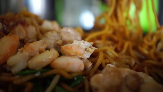 prawn fried noodle with blur chopsticks eating background