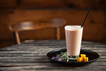 Fresh Mango smoothie on a dark wood background