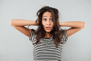 Frustrated confused asian woman keeping hands in her hair