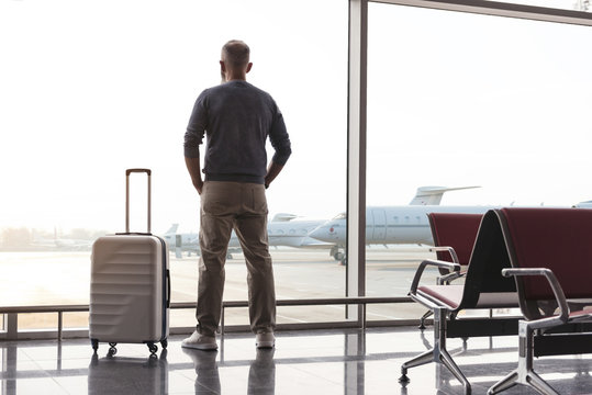 Adult man looking at window of airport