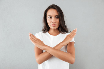 Angry serious asian woman showing crossed hands gesture