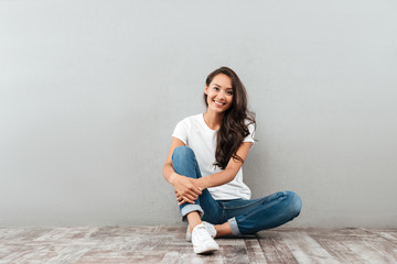 Happy pretty asian woman sitting and looking at camera