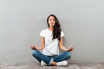 Beautiful young asian woman sitting in yoga position and meditating - Powered by Adobe