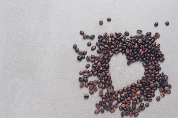 Heart of coffee beans on the grey surface. Valentine's day.