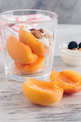 Dessert with peaches and whipped cream with nuts. Selective focus