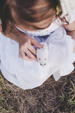 Girl holding white hamster - Top view - Retro look