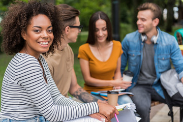 Cheerful young students talking in park