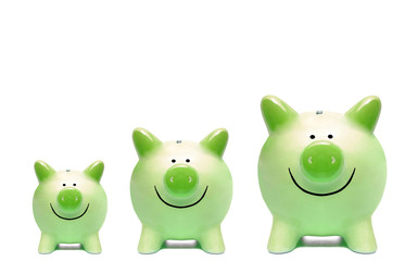 Three green piggy banks in different sizes / Green business and grown concept