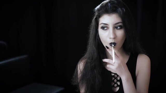 Goth girl with black eyes occasionally prefers dragging a 120mm cigarette. In this new video you can watch her looking straight into the camera, taking deep whiffs, skillfully flicking ash 