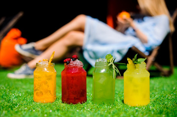 Homemade lemonade in glass bottles on the grass
