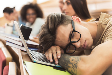 Bored male student sleeping on lecture
