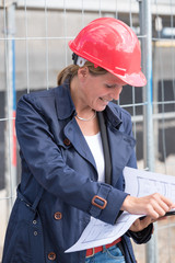 Architekt mit Plan auf der Baustelle