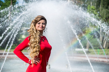 pretty girl in red dress against fountain