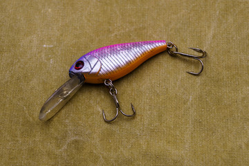 A bait for fishing on a tarpaulin background. Wobblers of different colors.