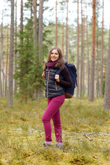 Young, beautiful and happy woman walking in forest. Camp, adventure, trip, hiking concept.