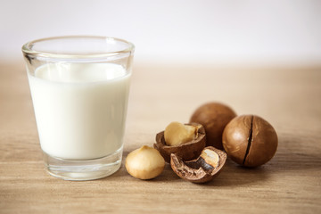 Close up the macadamia nut milk on wooden table , low fat healthy drink .