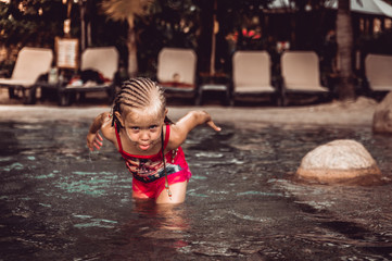 little girl is splashing in the pool