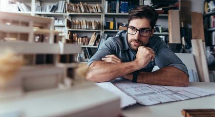 Architect looking at house model on desk