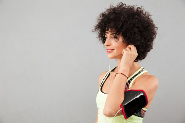 Fototapeta na wymiar Side view of curly fitness woman listening music
