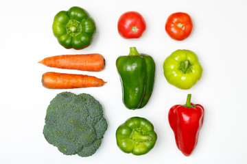 Vegan food. Top view of broccoli, green pepper, tomatoes, red paprika, carrot on a white background.