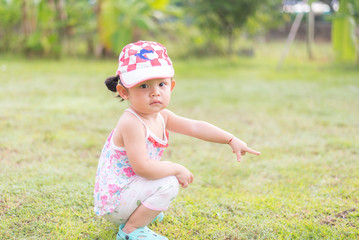 Asian cute litte girl pointing with finger on green background