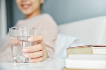 Woman holding glass of water.