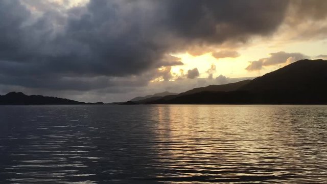 Overcast Sky darkens the rippling waters of a Scottish Loch as night draws in