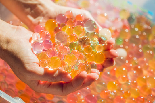 Colored balls of water beads, hydrogel in in hands. Sensory experiences