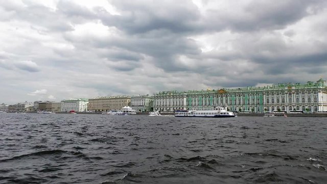 Passenger excursion ships and boats float on the Neva river past the Hermitage in Saint Petersburg, Russia. The tourist season in the Historic city Museum.