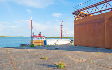 Rusty industrial steel construction on a quay below a blue sky