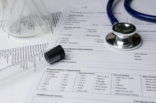 stethoscope, test tube, beaker and patient information form on desk, heart healthcare technology, medical diagnosis, blood test, medical report record and history patient concept, selective focus