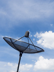 Black satellite dish or TV antennas install on the house roof on blue sky cloudy background.