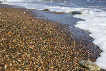 background texture of the sea coast with small and large pebbles