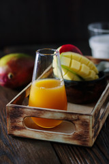 Glass with fresh mango juice in wooden box