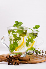Two glass cups fresh mint tea with lemon and honey on white background.